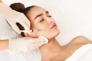 Plastic surgery procedure with a young woman receiving Botox injections at a beauty clinic for wrinkle reduction and facial rejuvenation