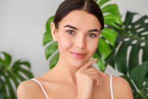 Young woman with clear, even-toned skin illustrating the results of hyperpigmentation correction treatment.